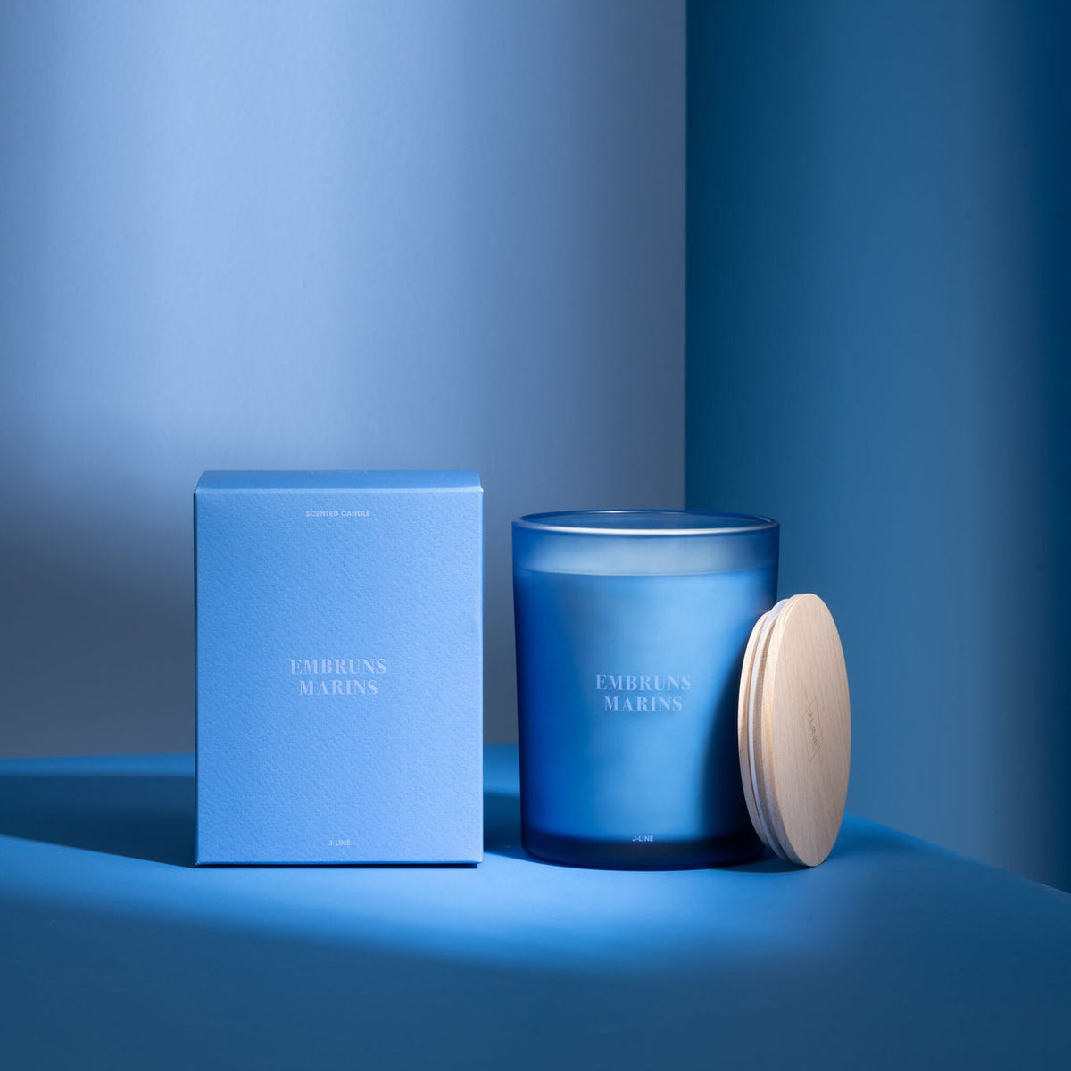 Geurkaars Accords Essentiels Embruns Marins 52 Uur van J-Line met bijpassende doos in een sfeervolle blauwe setting