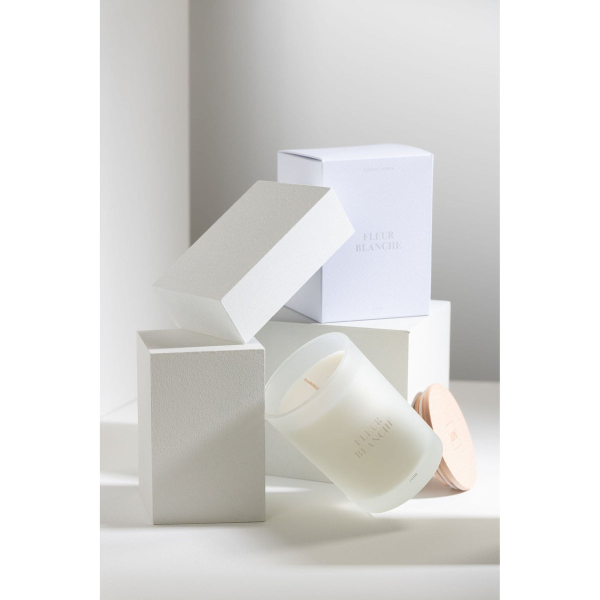 Geurkaars Accords Essentiels Fleur Blanche 38 Uur van J-Line op decoratieve blokken in een warme sfeerfoto