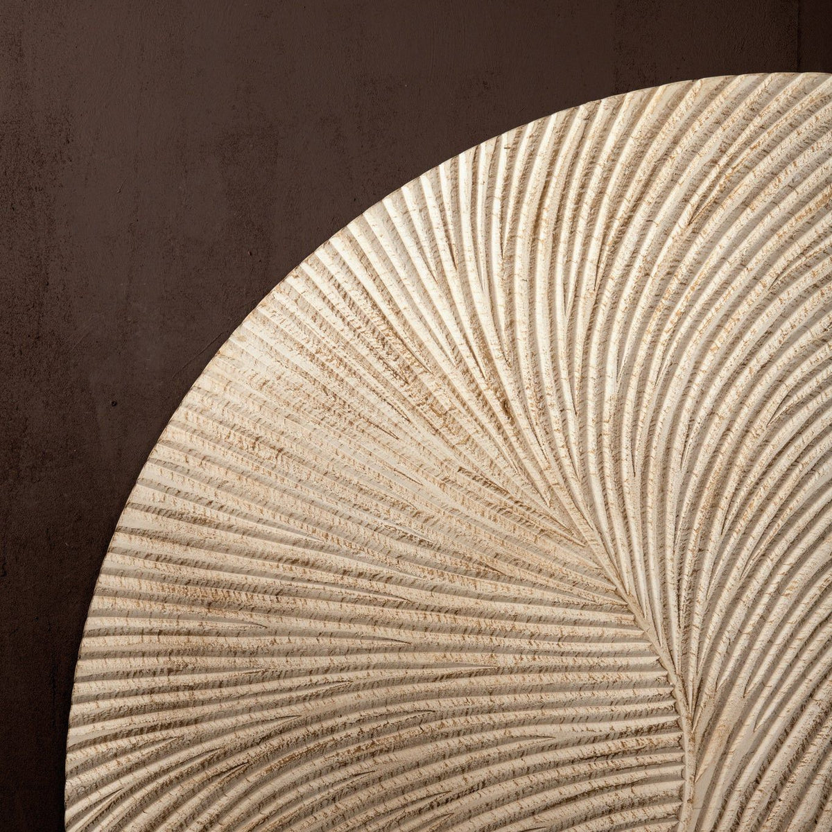Wandpaneel Wiktor Rond Wit Ø90cm van PTMD, detail van het reliëf in warm licht tegen een donkere muur