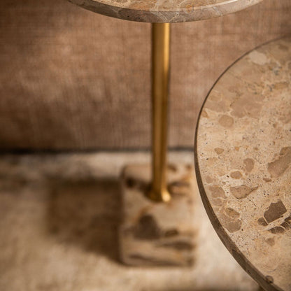 Detail van de Ebe bijzettafel van PTMD, goudkleurige stang op een blok beige marmer