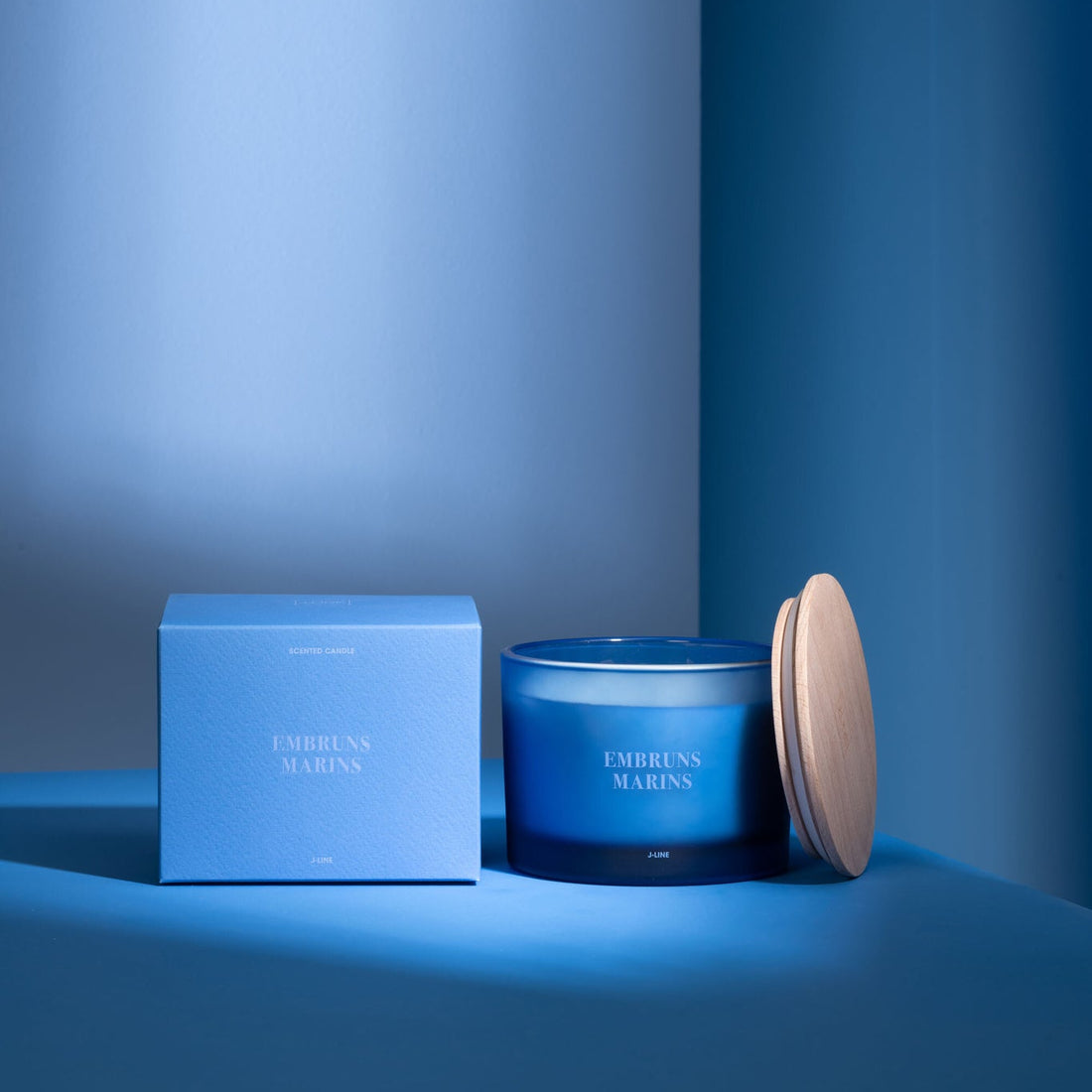 Geurkaars Accords Essentiels Embruns Marins 28 Uur van J-Line met bijpassende doos in een sfeervolle blauwe setting