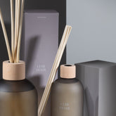 Geurstokjes Accords Essentiels Cuir Désir 250ml van J-Line op decoratieve blokken in een warme sfeerfoto