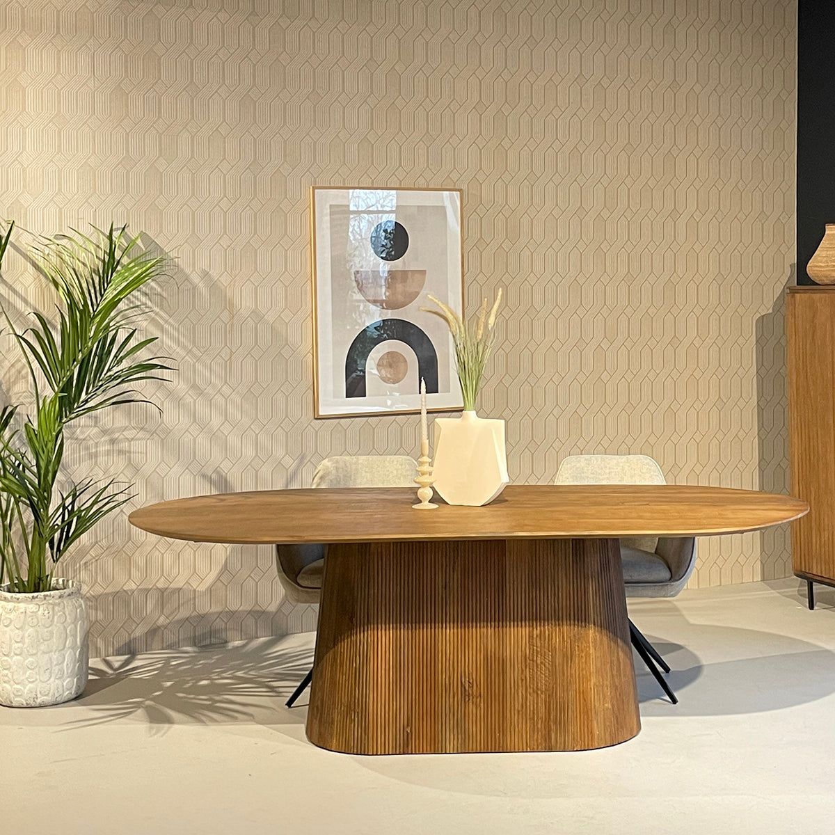Noor opbergkast tegen een donkere wand met een ovale eettafel ervoor