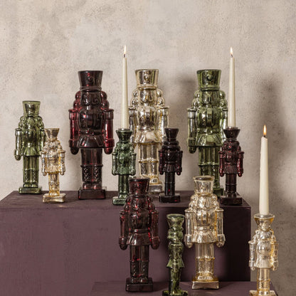 Set Van 2 Breyen Notenkrakers Glas Bordeaux van PTMD, sfeerbeeld met glazen notenkrakers in bordeaux, groen en goud op een kast