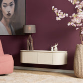 Sfeerbeeld van het zandkleurige tv-meubel Excellent aan de wand met decoratie